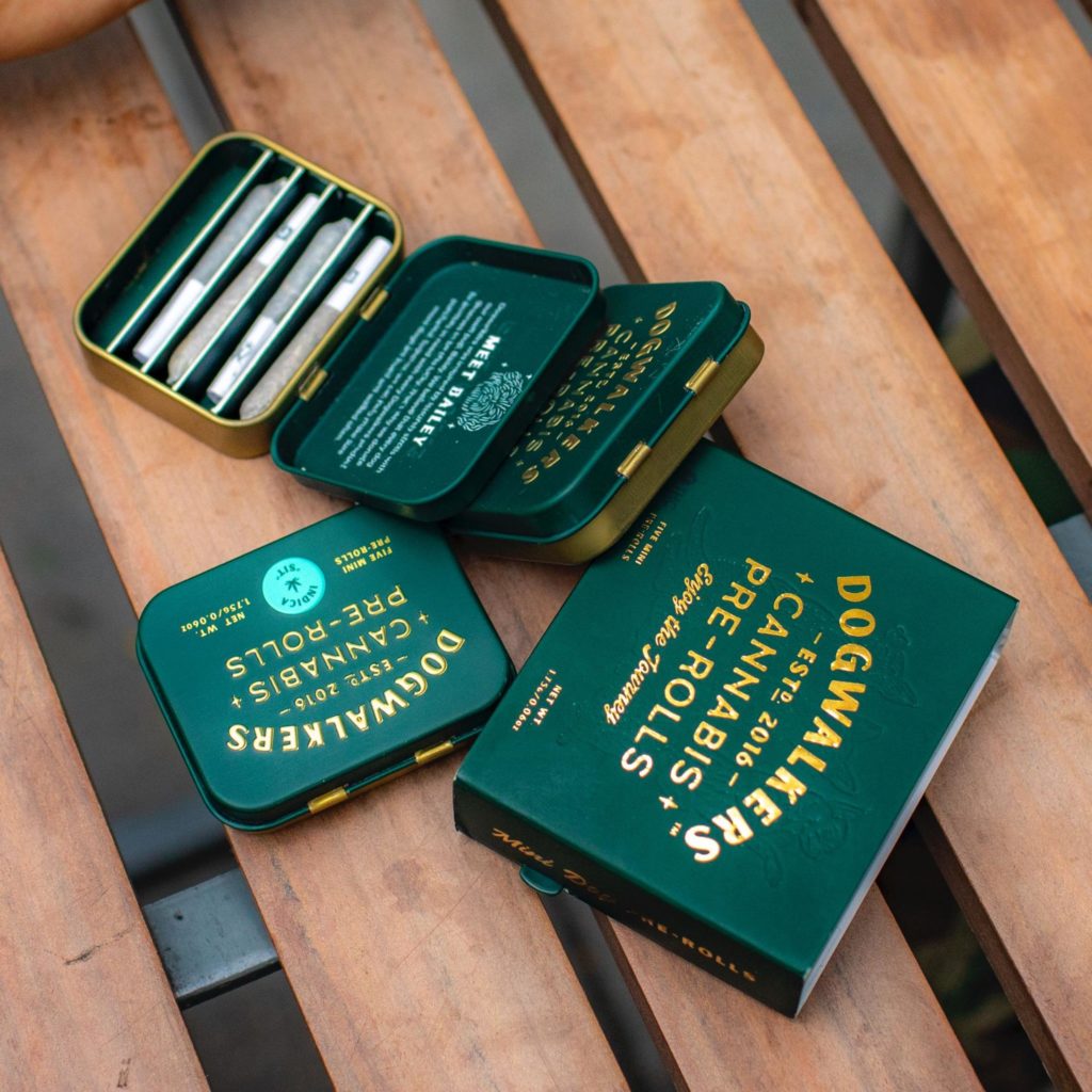 Cannabis pre-roll tins sitting on a wooden table